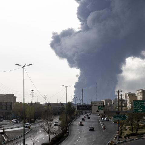 Cars drive down a highway as smoke billows after overnight airstrikes on oil depots on March 8, 2026, in Tehran, Iran. (Getty Images)