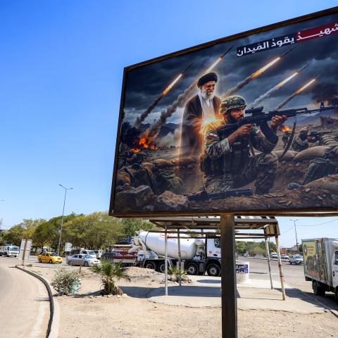 A billboard depicting Iran’s late supreme leader standing behind an Iranian soldier with a caption in Arabic reading "a martyr leads the battlefield" in western Baghdad on March 18, 2026. (Getty Images)