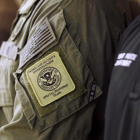 A member of the Homeland Security Investigations Special Response Team is seen wearing his uniform during Department of Homeland Security Secretary Kristi Noem's press conference at a federal office building on October 20, 2025 in Bradenton, Florida. The Secretary addressed ongoing immigration enforcement efforts and federal coordination with local authorities across the state, while praising President Donald Trump for their joint accomplishments under the "One, Big, Beautiful Bill," which received congress