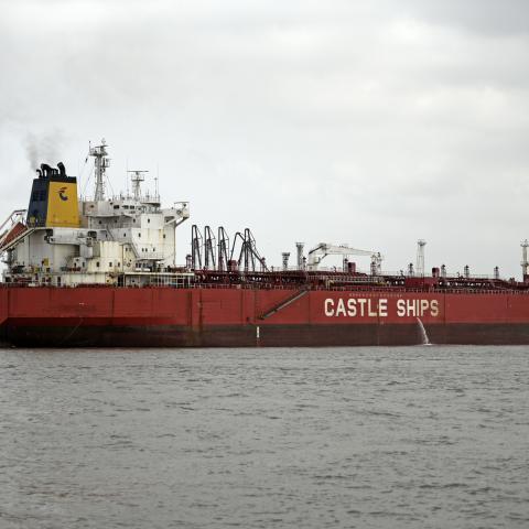 The cargo ship Castle Ships is seen near industrial structures along the shoreline under overcast skies in Mumbai, India, on April 1, 2026. (Photo by Indranil Aditya/NurPhoto via Getty Images)