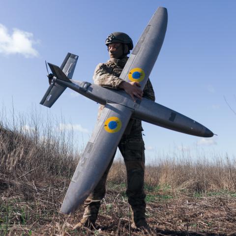 : A portrait of a soldier from the "Taifun" unmanned aerial vehicle unit holding a new model 'Marsianin' attack drone on April 7, 2026 in Kharkiv region, Ukraine. After years of developing systems and know-how to fend off Russia's drone attacks, Ukraine is now offering its hard-won expertise and counter-drone technology to other countries. In recent weeks, Ukrainian President Volodymyr Zelensky has been visiting Gulf states who are confronting a wave of relatively cheap kamikaze drones launched by Iran as i