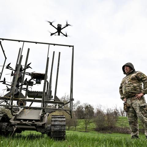 A soldier with the call sign ''Pavuk'' (''Spider'') watches a drone take off from a ground robotic complex during trials at a training ground on April 10, 2026. Developers of the robotic systems, along with soldiers from two brigades operating in the Zaporizhzhia direction, test unmanned ground vehicles (UGVs) at the site. Combat medics also train in operating logistical platforms. Before deployment in combat, the UGVs are first tested by the developers themselves, followed by the military. (Photo by Dmytro