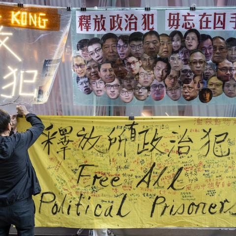  pro-democracy activist hangs a yellow banner with the message "Free All Political Prisoners" during a protest in Hong Kong. Pro-democracy activist Koo Sze-yiu stages a protest in Hong Kong, against the National Security Law (NSL) and demanding the release of all the political prisoners in Hong Kong. (Photo by Miguel Candela/SOPA Images/LightRocket via Getty Images)