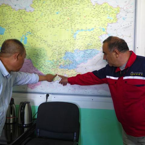 Caption Two men point at a map in an office on the grounds of the Saritag antimony mine in western Tajikistan on August 26, 2025. (Getty Images)