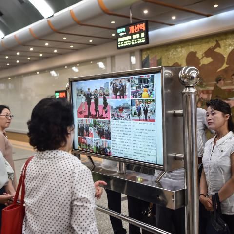 Commuters in the Kaeson Station of the Pyongyang Metro look at a screen with the newspaper “Rodongsinmun” showing news about Xi Jinping’s visit to North Korea on June 9, 2026. (Getty Images)