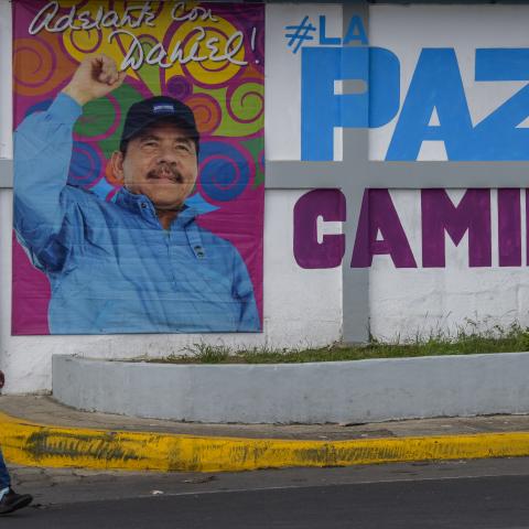 A woman walks in front of a billboard with a picture of Nicaraguan President Daniel Ortega at the Ministry of Family Economy on June 27, 2021, in Managua, Nicaragua. (Getty Images) Share to Twitter