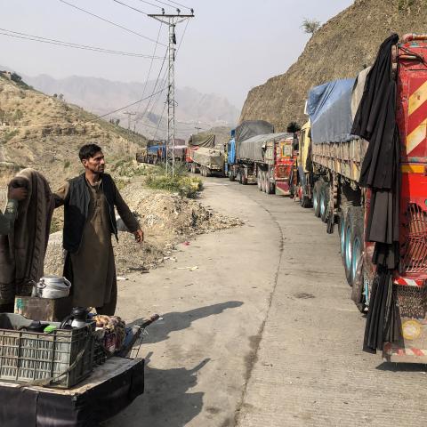 A tea vendor stands by stalled vehicles near the closed Pakistan-Afghanistan border town of Torkham on October 19, 2025. (Getty Images)