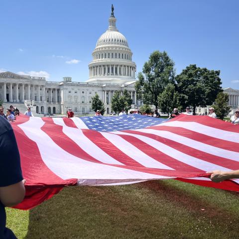 People deploy a large US flag near the US Capitol as part of the “Salute to America” Independence Day celebration on the National Mall in Washington, DC, on July 4, 2026. (Getty Images)