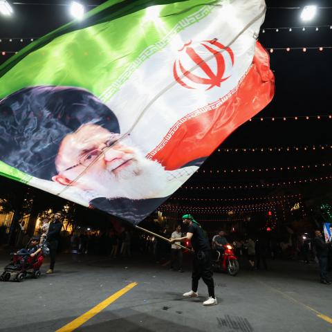 A man waves a flag near Imam Reza’s shrine in Mashhad, Iran, on July 9, 2026. (Getty Images)
