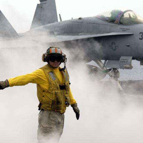 A sailor prepares to launch an F/A-18C Hornet off the flight deck of the USS Kitty Hawk in the Philippine Sea on May 6, 2008. (US Navy)