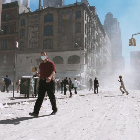 An unidentified man with a face mask walks on an ash-covered street near Ground Zero after the collapse of the Twin Towers on September 11, 2001, in New York City. (Getty Images)