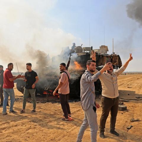Palestinians take control of an Israeli Merkava battle tank after crossing the border fence with Israel from Khan Yunis in the southern Gaza Strip on October 7, 2023. (Getty Images)