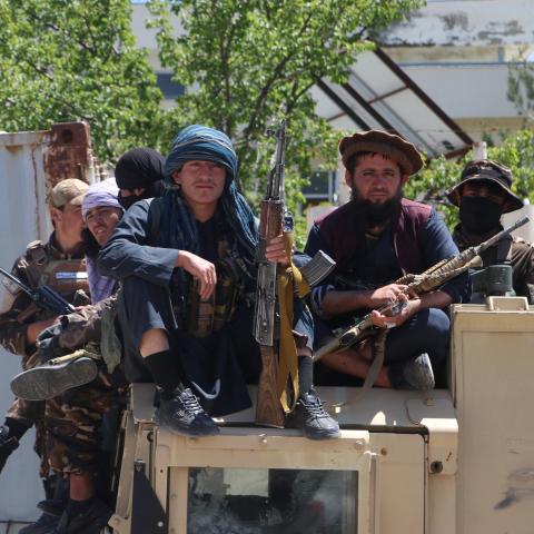 Armed Taliban security personnel sit on a humvee armoured vehicle outside a mosque in Argo district, Badakhshan province on May 6, 2024. From satellite images, Afghanistan's Taliban rulers have seen success in slashing opium production, but on the ground, farmers stripped of their livelihoods have resisted anti-narcotics units -- sometimes at the cost of their lives.The end of last week was marked by violent clashes in mountainous Badakhshan province that left two dead, according to provincial police (Photo