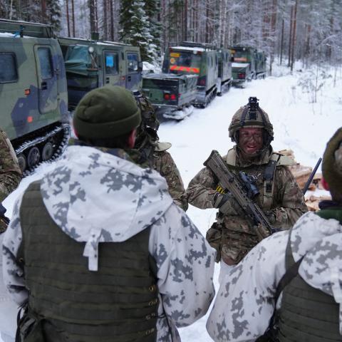 A British corporal talks with Finnish soldiers at Vuosanka near Kajaani, Finland, during NATO’s Northern Axe exercise along the Russian border. (Getty Images)