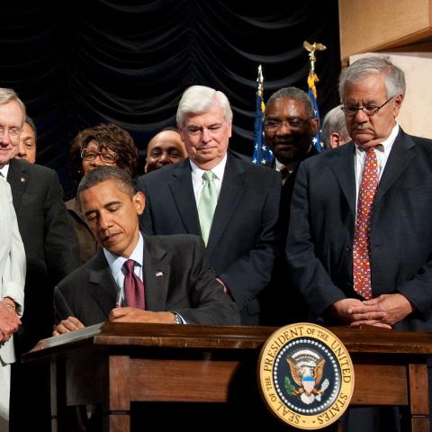 US President Barack Obama signs the Dodd-Frank Wall Street Reform and Consumer Protection Act alongside members of Congress and the administration in Washington, DC, on July 21, 2010. (Getty Images)