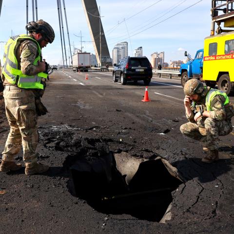 Police officers look at the damages following a Russian drone strike on the Northern Bridge in Kyiv on October 4, 2026, amid the Russian invasion of Ukraine. Russia struck another major bridge in Kyiv on October 4, soon after Germany's chancellor arrived on a surprise visit to show European support in the face of an upsurge in attacks. (Photo by Mykola TYMCHENKO / AFP via Getty Images)
