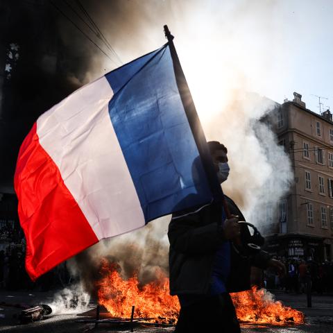 A protester walks past a fire during clashes prior to the start of a protest in Marseille, France, on October 17, 2026. (Getty Images)