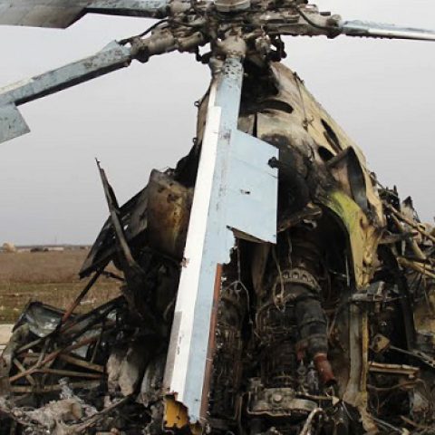 Rebel fighters inspecting the wreckage of a Syrian army helicopter after Islamic State of Iraq and the Levant (ISIL)'s fighters allegedly destroyed it when they left the Meng Military Airport, Aleppo, March 1, 2014 (MOHAMMED AL-KHATIEB/AFP/Getty Images)