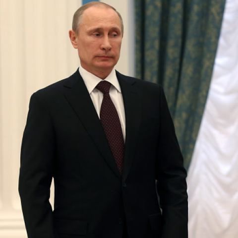 Russia's President Vladimir Putin after signing a law on ratification of a treaty making Crimea part of Russia in the Kremlin in Moscow March 21, 2014, with Valentina Matviyenko (L) and Sergei Naryshkin (R) applauding. (SERGEI CHIRIKOV/AFP/Getty Images)