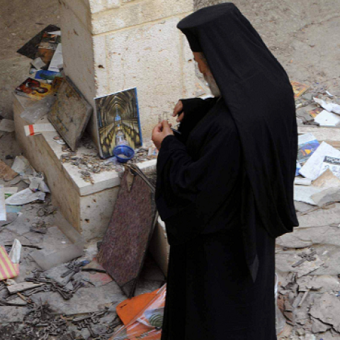 A Christian priest inspects the damages inside a church in the ancient Christian town of Maalula, northeast of Damascus on April 14, 2014 AFP/Getty Images)