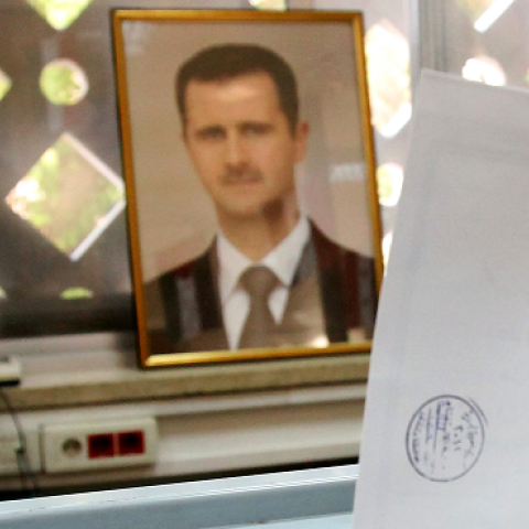 A Syrian man casts his ballot in front of a picture of Syrian President Bashar al-Assad at a polling station in Damascus on February 26, 2012 (ANWAR AMRO/AFP/Getty Images)