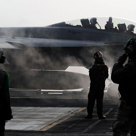 US Navy crew members on deck as a F-18 Super Hornet strike fighter plane takes off from the USS George Washington on the Korean Peninsula's west sea on November 30, 2010 (Song Kyung-Seok - pool/Getty Images)