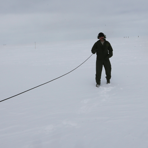 A crew member of a ski-equipped C-130 from the New York Air National Guard stands near the plane on July 11, 2013 at the Summit Station, Greenland. (Joe Raedle/Getty Images)
