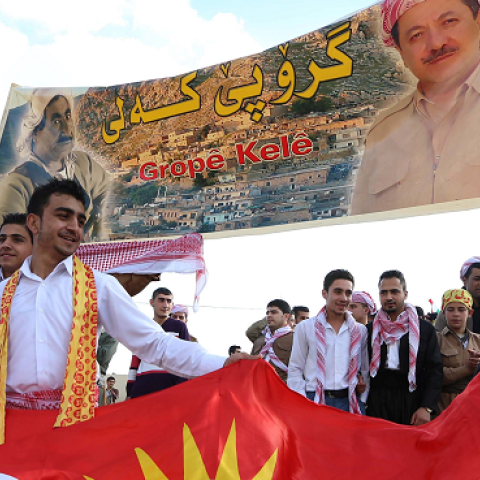Iraqi Kurds hold the Kurdish flag and a poster of Iraqi Kurdistan's regional president Masoud Barzani (R) in Akra, Iraq's, March 20, 2014. (SAFIN HAMED/AFP/Getty Images)