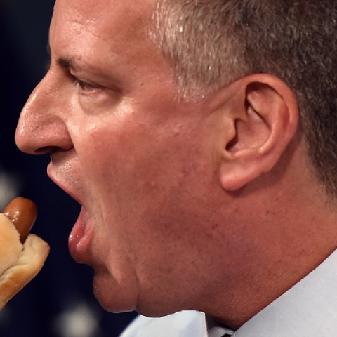 New York City Mayor Bill de Blasio bites a hot dog on July 3, 2014 at City Hall in New York. (DON EMMERT/AFP/Getty Images)