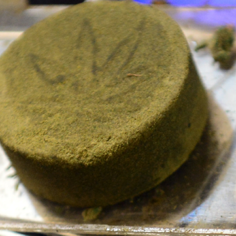 Kief, pressed into a cake of hashish, on a scale at a medical marijuana dispensary in Los Angeles, California on July 4, 2014. (FREDERIC J. BROWN/AFP/Getty Images)