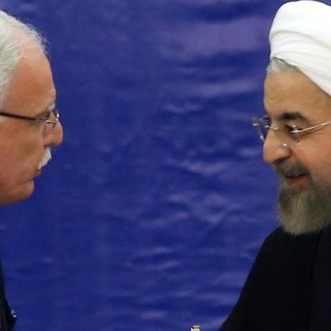 Palestinian Foreign Minister Riyad al-Maliki (L) and Iranian President Hassan Rouhani shake hands during a meeting in Tehran held by the Palestine Committee of the Non-Aligned Movement (NAM) on August 4, 2014. (ATTA KENARE/AFP/Getty Images)