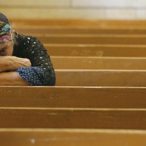 An Iraqi Christian fleeing the violence in the towns of Qaraqush and Bartala prays at the Saint George church on July 1, 2014 in Arbil.(KARIM SAHIB/AFP/Getty Images)