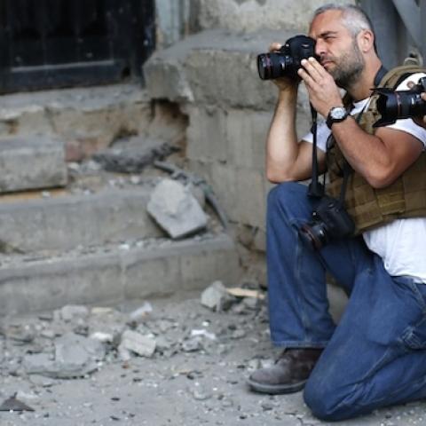 New York Times Photographer Tyler Hicks (2ndR) takes pictures of Palestinians in Gaza City on July 16, 2014. (THOMAS COEX/AFP/Getty Images)