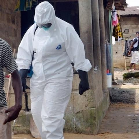 Nurses wearing protective suits escort a man infected with the Ebola virus to a hospital in Monrovia, August 25, 2014. (ZOOM DOSSO/AFP/Getty Images)