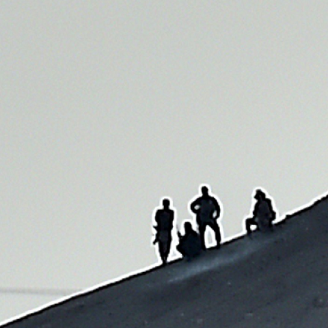 Alleged Islamic State (IS) militants stand next to an IS flag atop a hill in the Syrian town of Ain al-Arab, on October 6, 2014. (ARIS MESSINIS/AFP/Getty Images)