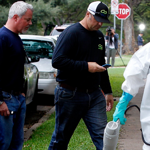 A man dressed in protective hazmat clothing leaves after treating the front porch and sidewalk of an apartment where a second person diagnosed with the Ebola virus resides on October 12, 2014 in Dallas, Texas. (Mike Stone/Getty Images)