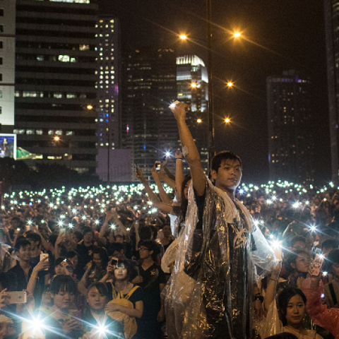 Protesters sing songs and wave their cell phones in the air after a massive thunderstorm passed over outside the Hong Kong Government Complex on September 30, 2014. (Chris McGrath/Getty Images)