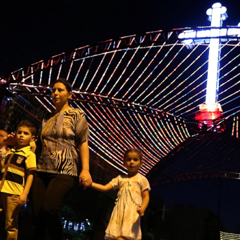 Iraqi Christians walk past a decorations displayed in commemoration of the Elevation of the Holy Cross festival on September 14, 2014, in Arbil, the capital of the Kurdish autonomous region in northern Iraq. (SAFIN HAMED/AFP/Getty Images)