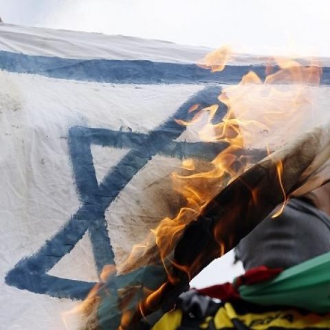 A pro-Palestinian demonstrator holds up a burning Israeli flag on the Republique square in Paris on July 26, 2014. (KENZO TRIBOUILLARD/AFP/Getty Images)