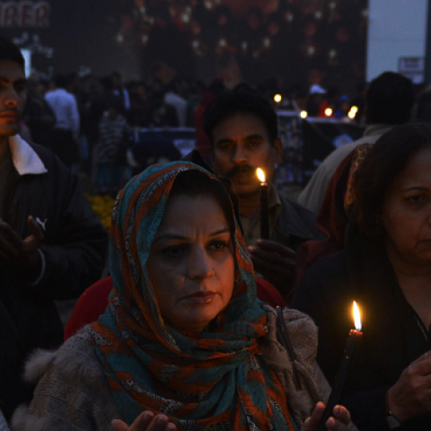 Pakistani civil society activists pray during a vigil in Lahore on December 18, 2014, for the children and teachers killed in an attack by militants on an army-run school in Peshawar. (Arif Ali/AFP/Getty Images)