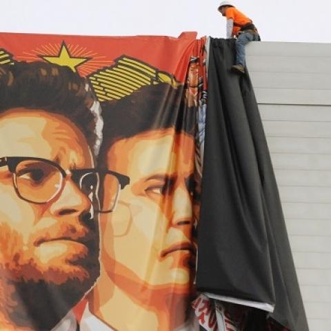 Workers remove a poster-banner for 'The Interview' from a billboard in Hollywood, California, December 18, 2014 a day after Sony announced was cancelling the movie's Christmas release due to a terrorist threat. (Michael THURSTON/AFP/Getty Images)