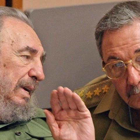 Cuban President Fidel Castro (L) and his brother Raul, Minister of the Revoutionary Armed Forces,  in Havana, during a meeting of the Cuban Parliament, December 23, 2003. (ADALBERTO ROQUE/AFP/Getty Images)