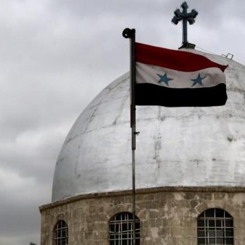 The Syrian flag flying in front of the dome of the Syrian Saint Sarkis Church for Armenian Orthodox in Damascus on January 6, 2015. (LOUAI BESHARA/AFP/Getty Images)