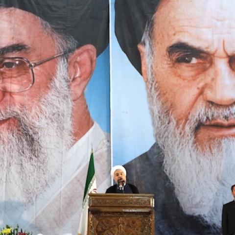 Iranian President Hassan Rouhani under portraits of Iran's supreme leader, Ayatollah Ali Khamenei (C-L) and Iran's founder of the Islamic Republic, Ayatollah Ruhollah Khomeini (C-R), in a suburb of Tehran on June 3, 2014. (ATTA KENARE/AFP/Getty Images)