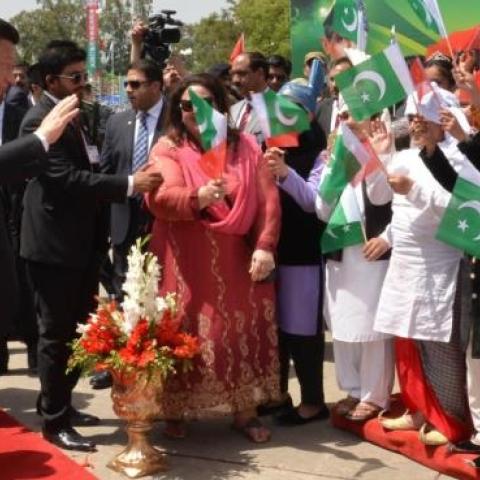 Chinese President Xi Jinping waves to Pakistani children as his Pakistani counterpart Mamnoon Hussain (L) and Pakistani Prime Minister Nawaz Sharif (C, back) look on, upon arrival at Islamabad airport in Islamabad, on April 20, 2015. (Photo by (Pakistan P