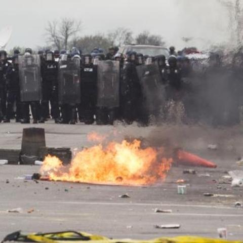 With Baltimore Police officers in riot gear lining the street, a man stands at the corner of Pennsylvania Avenue and North Avenue , April 27, 2015 in Baltimore, Maryland. (Drew Angerer/Getty Images)