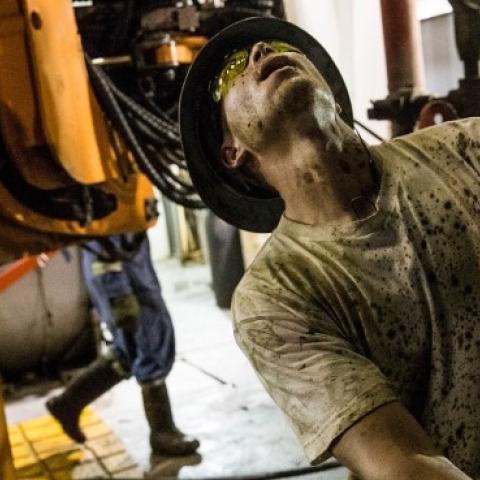 Russell Girsh, a floor hand for Raven Drilling, helps line up a pipe while drilling for oil in the Bakken shale formation on July 23, 2013 outside Watford City, North Dakota. (Andrew Burton/Getty Images)