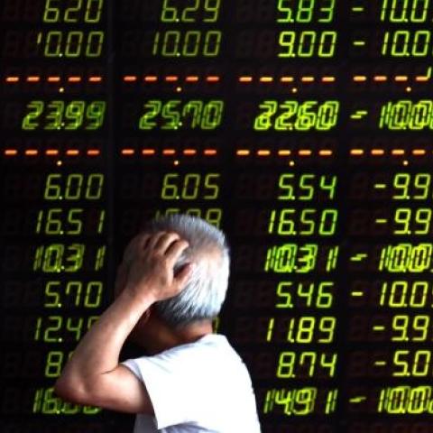 An investor looks through stock information at a trading hall in Shenyang, China, July 7, 2015. (Xinhua/Pan Yulong via Getty Images)