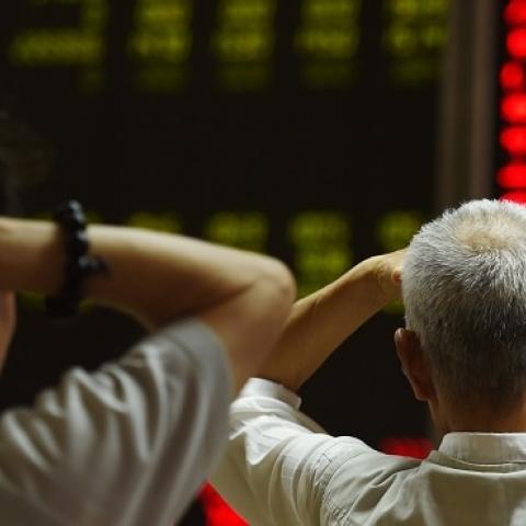 Investors look at screens showing stock market movements at a securities company in Beijing on July 14, 2015. (GREG BAKER/AFP/Getty Images)