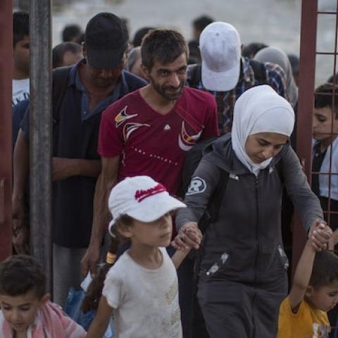 After having their papers processed, migrant families walk out of a transit area toward a train station, Sept. 3, Gevgelija, Macedonia. (Dan Kitwood/Getty Images)